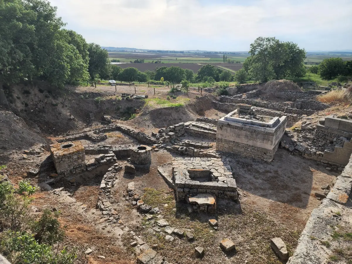 Excavated stone house foundations and a defensive wall at the archaeological site of Troy, Turkey